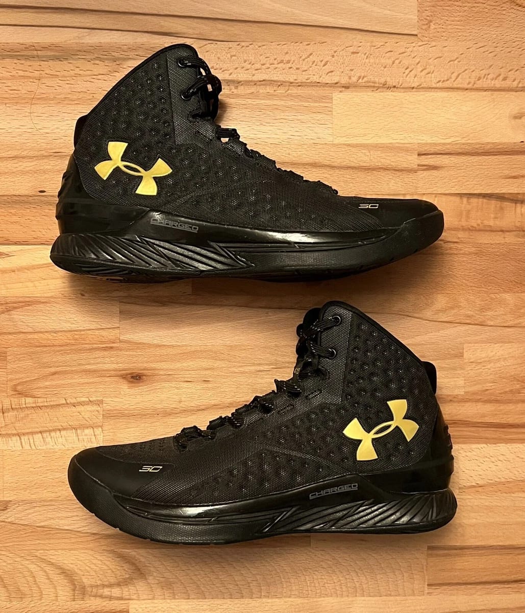 UNDR ARMR CURRY 1 GOLD BANNER BLACKOUT [BLACK / GOLDEN] 1501026
